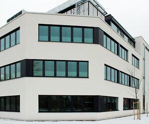 Große helle Fensterfronten im dreistöckigen Forschungszentrum in München